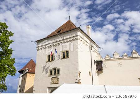 Kezmarok Castle tower with flags against blue sky Kezmarok Castle tower with flags against blue sky 136587976
