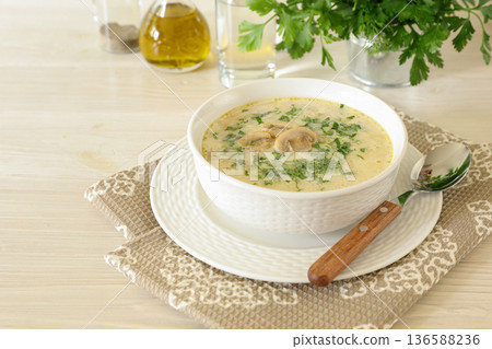Tasty champignon mushrooms soup with cream and cheese in white bowl on white wooden background. Horizontal. Daylight. Close up. Tasty champignon mushrooms soup with cream and cheese in white bowl on white wooden background. Horizontal. Daylight. Close up. 136588236
