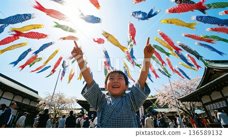 五月晴朗的天空飄揚著鯉魚旗，一個男孩面帶微笑，眼神夢幻地指向天空。 136589132