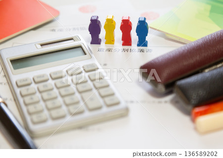 遺產分割協議和木製小人偶、計算器、印章、存摺。財產分割、繼承、金錢意象。 136589202