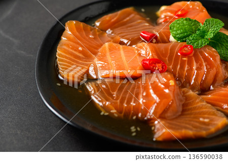 Korean Soy Marinated Salmon (Salmon Jang) on Black Plate with Chili and Mint Korean Soy Marinated Salmon (Salmon Jang) on Black Plate with Chili and Mint 136590038
