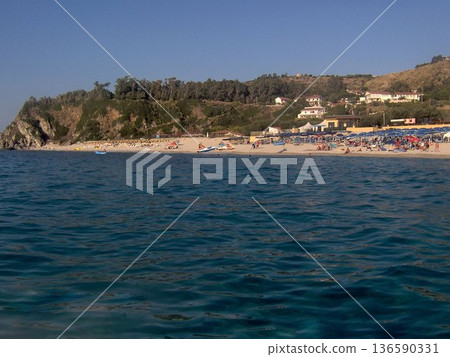 Beautiful panoramic view of the Calabrian coast during the summer season, featuring turquoise crystal-clear waters, dramatic rocky cliffs, and charming seaside scenery under bright blue skies. The Beautiful panoramic view of the Calabrian coast during the summer season, featuring turquoise crystal-clear waters, dramatic rocky cliffs, and charming seaside scenery under bright blue skies. The 136590331