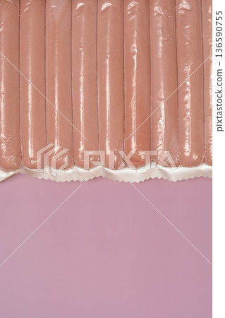 Vacuum sealed sausages on pink background Vacuum sealed sausages on pink background 136590755