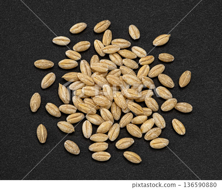 Barley grain pile on dark background, natural whole cereal ingredient, full depth of field, top view Barley grain pile on dark background, natural whole cereal ingredient, full depth of field, top view 136590880