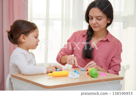 Mother and daughter enjoying creative learning time with modeling clay at home 136590955