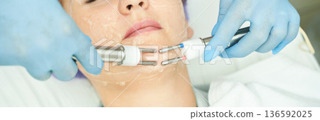 Female receiving facial skin treatment with electrotherapy at spa 136592025