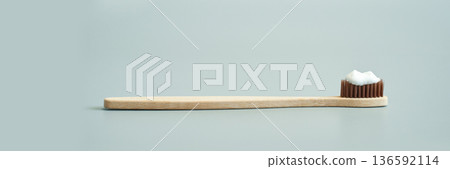 Bamboo toothbrush with toothpaste on eco-friendly bristles in minimalist Bamboo toothbrush with toothpaste on eco-friendly bristles in minimalist 136592114