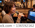 A woman singing at a karaoke bar 136592162