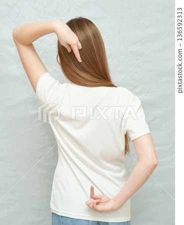 Caucasian young female showing back with finger gesture in casual white t-shirt Caucasian young female showing back with finger gesture in casual white t-shirt 136592313