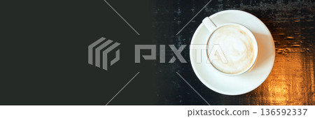 Top view of cappuccino in white cup on dark wooden table with empty space 136592337
