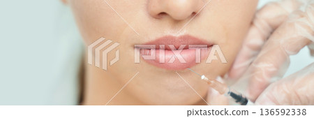 Close-up of female lips with injection for cosmetic enhancement by doctor Close-up of female lips with injection for cosmetic enhancement by doctor 136592338