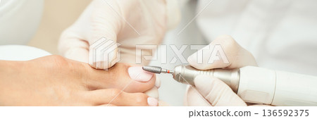 Close-up of professional pedicure: foot care with electric nail file Close-up of professional pedicure: foot care with electric nail file 136592375