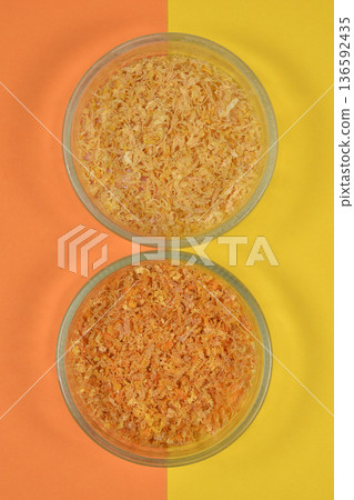 Dried orange and lemon peel in glass bowls on split background Dried orange and lemon peel in glass bowls on split background 136592435