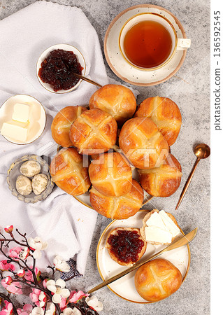 Festive Easter treat. Easter buns are decorated with a cross, jam, butter, and cherry blossoms. English buns are baked on Friday and served with tea the morning before Easter Sunday 136592545
