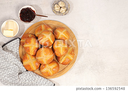 Festive Easter treat. Easter buns with a cross, jam, and butter. These homemade English buns are baked on Friday and served with tea the morning before Easter Sunday. Happy Easter. 136592548