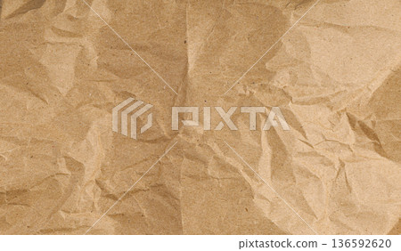 Crumpled brown kraft paper texture isolated on white background. Ripped recycled paper sheet. Crumpled brown kraft paper texture isolated on white background. Ripped recycled paper sheet. 136592620