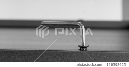 Metal Allen Key Engaged in Hex Screw on Dark Surface Metal Allen Key Engaged in Hex Screw on Dark Surface 136592625