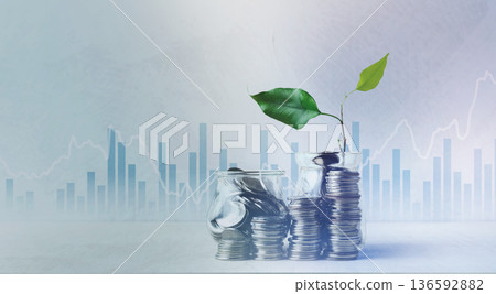 Coins in glass jars with a plant growing on top against a graph background 136592882