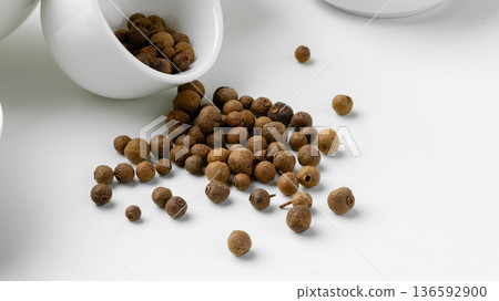 Spices spilled from a white container on a clean surface in a kitchen setting 136592900