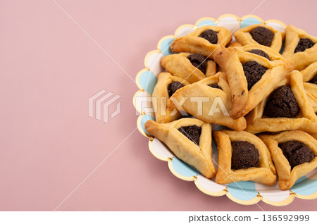 Purim celebration concept, jewish carnival holiday. Hamantaschen cookies over white neutral rose background 136592999