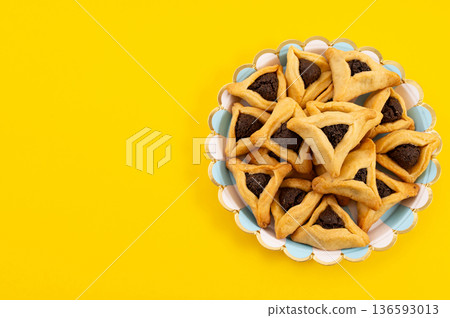 Blank card with Hamantaschen cookies and confetti for Purim holiday on yellow background Blank card with Hamantaschen cookies and confetti for Purim holiday on yellow background 136593013