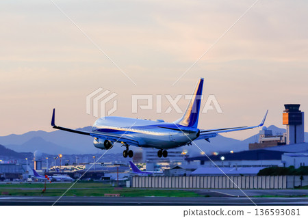 日落時分，一架客機降落在跑道上。 136593081