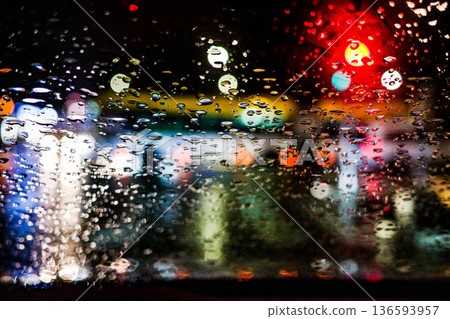 Rain drops on glass with colorful city lights bokeh at night 136593957