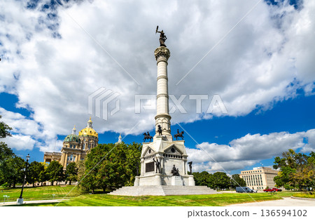 Soldiers and Sailors Monument in Des Moines Iowa. Historic Civil War memorial features a tall granite column and statues with the State Capitol golden dome in the background 136594102