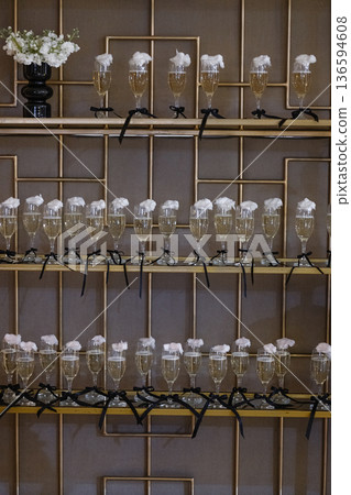 Display of champagne flutes with cotton candy on golden multi-level shelf stand 136594608