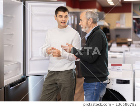 Men in the store choose a refrigerator Men in the store choose a refrigerator 136596782