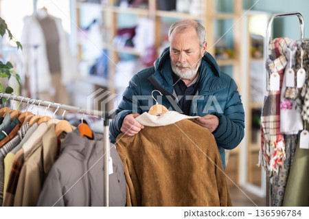 Family clothing store, senior man customer choose sheepskin coat 136596784