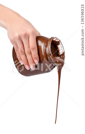 Chocolate stream pouring from jar in female hand isolated on white Chocolate stream pouring from jar in female hand isolated on white 136596818