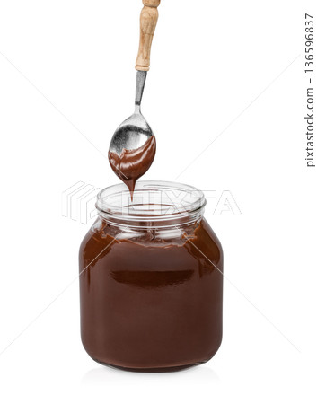 Chocolate Spread Dripping from Spoon into Glass Jar Isolated on White Chocolate Spread Dripping from Spoon into Glass Jar Isolated on White 136596837