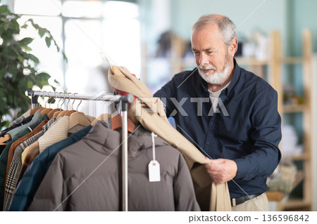 Family clothing store, senior man customer choose raincoat 136596842