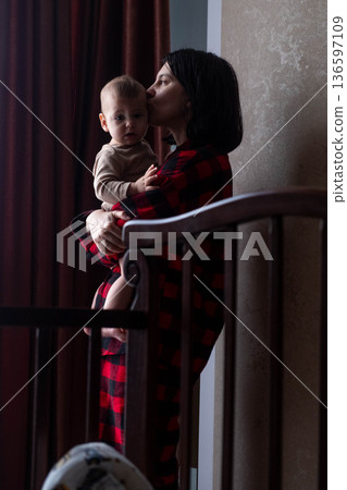 Mother Holding Baby in Dimly Lit Room Mother Holding Baby in Dimly Lit Room 136597109