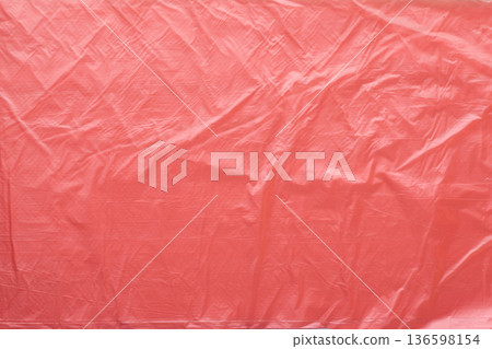 Abstract background of crumpled red plastic material symbolizing plastic waste pollution. Synthetic material texture, environmental issue, environmental concept Abstract background of crumpled red plastic material symbolizing plastic waste pollution. Synthetic material texture, environmental issue, environmental concept 136598154