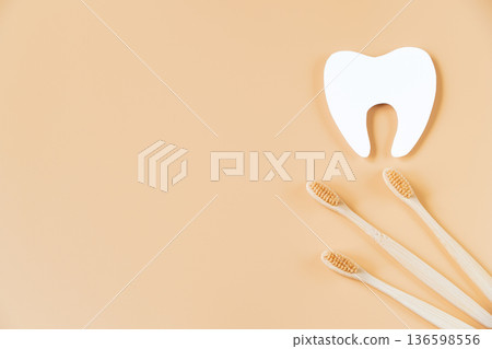 Eco-friendly wooden toothbrushes on trendy beige background. Dental care concept. Happy dentist day. Eco-friendly wooden toothbrushes on trendy beige background. Dental care concept. Happy dentist day. 136598556