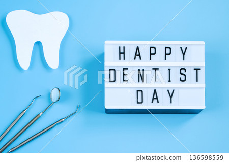 Paper cut mockup of tooth and dental instrument on blue background. Dental care concept. International Dentist Day. Paper cut mockup of tooth and dental instrument on blue background. Dental care concept. International Dentist Day. 136598559