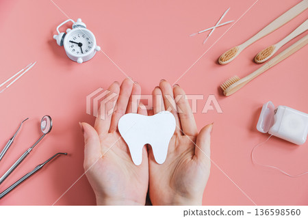 Hands holding paper cut mockup of tooth. Dental care concept. Happy dentist day. Hands holding paper cut mockup of tooth. Dental care concept. Happy dentist day. 136598560