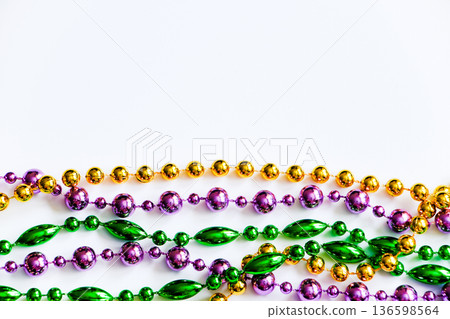 Mardi Gras background. Gold, green and purple beads on white background. Fat Tuesday symbol. Mardi Gras background. Gold, green and purple beads on white background. Fat Tuesday symbol. 136598564