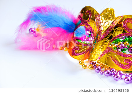 Golden carnival mask and colorful beads on white background. Closeup symbol of Mardi Gras or Fat Tuesday. 136598566