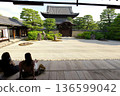 一位女子正在欣賞禪寺花園裡鬱鬱蔥蔥的植物。 136599042