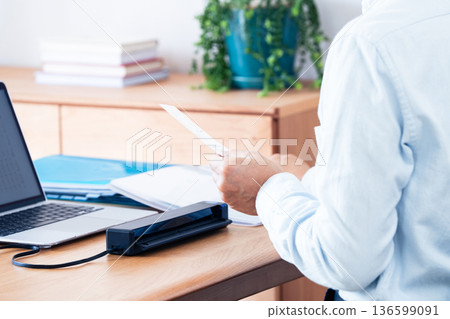 一名男子的手正準備提交他的報稅表 136599091