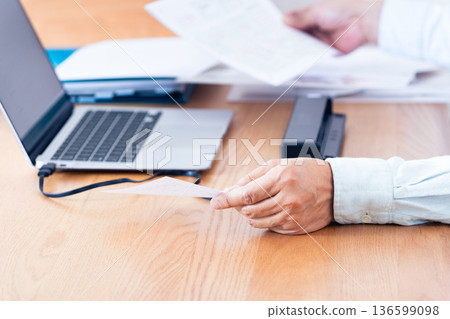 Hands of a man preparing to file his tax return 136599098