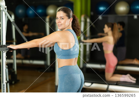 Young woman doing abdominal exercises on reformer Young woman doing abdominal exercises on reformer 136599265