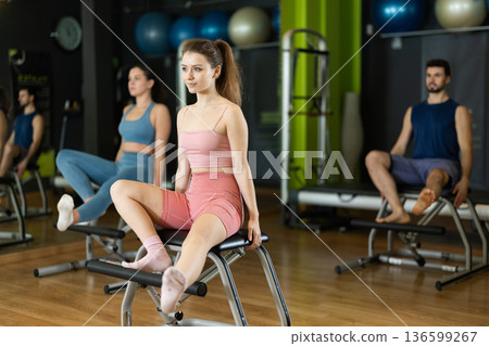 Young girl doing leg presses on pilates chair Young girl doing leg presses on pilates chair 136599267
