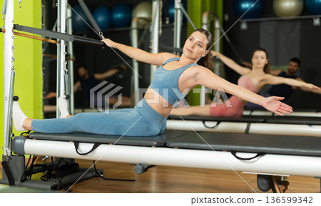 Young woman doing abdominal exercises on reformer 136599342