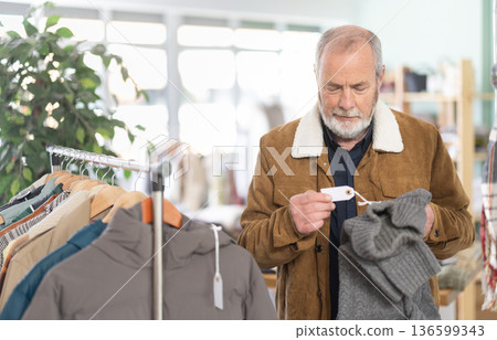 Elderly man choosing jersey knitted sweaters 136599343