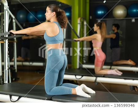 Young woman doing abdominal exercises on reformer 136599346