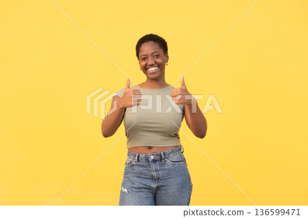 Cheerful woman showing thumbs up with both hands 136599471